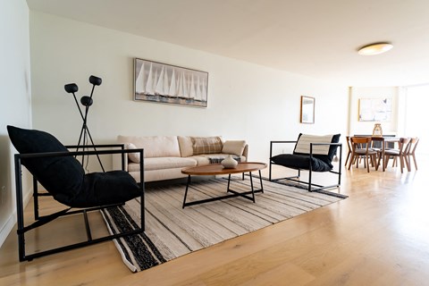 a living room with a couch and chairs and a dining room table